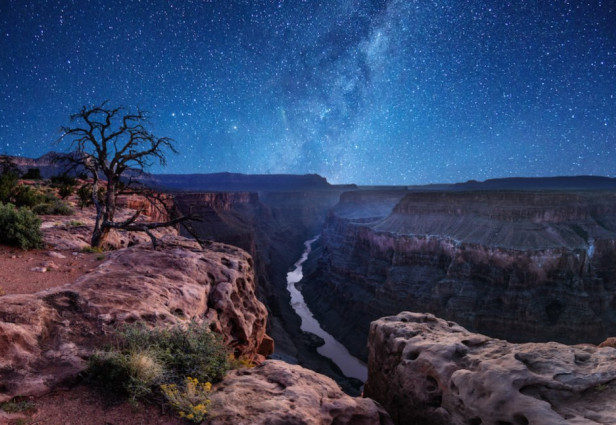 Yöllä Grand Canyonin kansallispuiston yllä Linnunrata heijastuu jokeen. Lähde: Travel Awaits