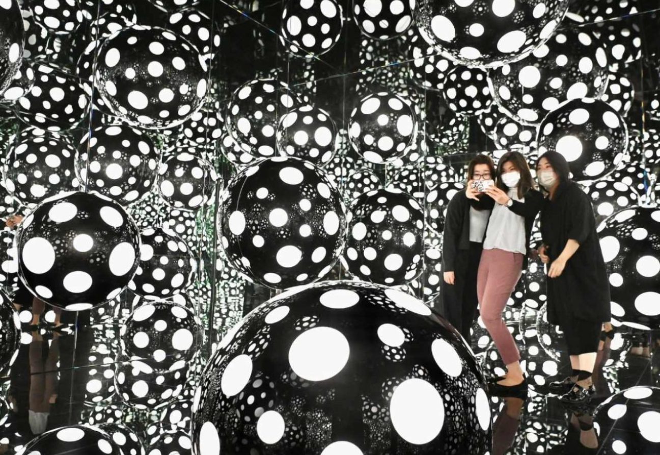 Personas tomándose selfies en la sala infinita de la exhibición. Foto: ARTnews